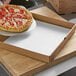 A pepperoni pizza being cut into slices in a Choice pizza box on a table.