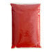 A red plastic bag of Red Gold tomato ketchup on a white background.