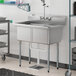 A Steelton stainless steel two compartment sink on a counter with a faucet.