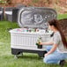 A woman opening an Igloo Party Bar cooler to put in bottles.