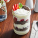 A Yoplait Parfait made with vanilla yogurt, strawberries, and granola in a glass jar.