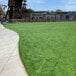 A green grass field with a concrete path.