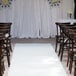 A white FloorEXP carpet runner at a wedding ceremony with chairs.