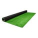 A roll of green artificial turf with black material covering it.