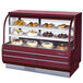 A red Turbo Air refrigerated bakery display case with cakes and pastries on display.