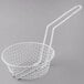 A white wire breading basket with a long handle.