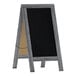 A Flash Furniture Canterbury vintage graywashed wood A-frame chalkboard with a black board.