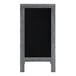 A wooden A-frame chalkboard with a black board on it in a wooden frame.