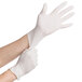 A pair of hands putting on white disposable latex gloves.