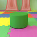 A green Flash Furniture Nicholas flexible soft seating circle ottoman on a colorful surface.