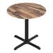 A Holland Bar Stool round wooden table with a black base.