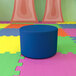 A blue cylinder on a colorful surface.