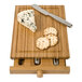A Franmara bamboo cutting board with cheese tools holding cheese and crackers.
