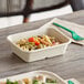 A World Centric compostable fiber container with pasta and vegetables on a table.
