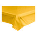 A yellow plastic Choice tablecloth on a white table.