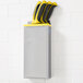 An Edlund stainless steel knife rack with a yellow insert holding knives.