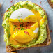 A slice of toast with avocado spread and a Yo Egg poached egg on top.