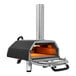 A black and silver Ooni Karu 16 outdoor pizza oven with a metal pipe.
