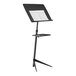 A black National Public Seating music stand with sheet music on it.