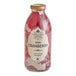 A close up of a Harney & Sons Organic Cranberry Juice bottle with red liquid inside.