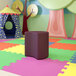 A purple flexible moon-shaped ottoman in a colorful playroom.