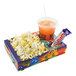 A Winco paper food tray with a box of popcorn and a drink in it.