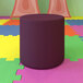 A purple Flash Furniture Nicholas flexible soft seating ottoman on a colorful surface.