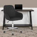 A black Flash Furniture office chair with wheels at a desk with a laptop.