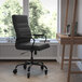 A Flash Furniture black leather office chair with wheels at a desk.