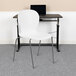 A Flash Furniture Hercules white contoured stacking chair in front of a desk.