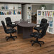 A Flash Furniture Lake Rustic Gray oval conference table with four black leather office chairs.