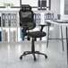 A Flash Furniture black mesh office chair in front of a white desk.