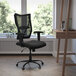 A Flash Furniture black mesh big and tall office chair at a desk with a laptop and book.