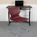 A Flash Furniture burgundy chair with a gray sled base sits in front of a desk.