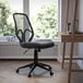 A Flash Furniture black mesh high-back swivel office chair in a room with a window.