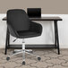 A Flash Furniture black leather office chair with wheels next to a desk.