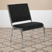A Flash Furniture Hercules black fabric reception chair with chrome legs in a room.
