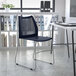 A Flash Furniture navy stacking chair with a gray sled base at a white table.