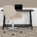 A Flash Furniture beige fabric office chair with wheels and a black laptop on the desk.