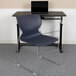 A blue Flash Furniture Hercules stacking chair with a gray sled base next to a desk with a laptop on it.