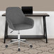 A Flash Furniture dark gray office chair with wheels next to a desk.