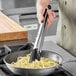 Choice 16" Silicone Tip Locking Tongs being used to cook spaghetti in a pan.