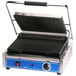 A Globe panini sandwich grill with a blue handle on a counter.
