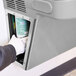 A person in gloves using a hand to open a maintenance panel on an Elkay water cooler.