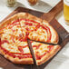 A pizza with Miyoko's vegan mozzarella and sauce on a wooden board with a slice missing.