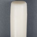 A 15 inch ivory Will & Baumer taper candle on a gray surface.