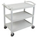 A speckled gray Cambro utility cart with three shelves and black wheels.
