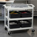 A Cambro speckled gray utility cart with black shelves holding black plastic containers.