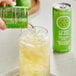 A hand pouring Izze Apple Sparkling Juice from a green can into a glass.