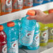 A hand holding a blue Gatorade Thirst Quencher Frost Glacier Freeze sports drink bottle.